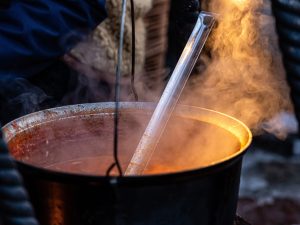 large metal soup pot on an open fire at an open-air Christmas ma 1