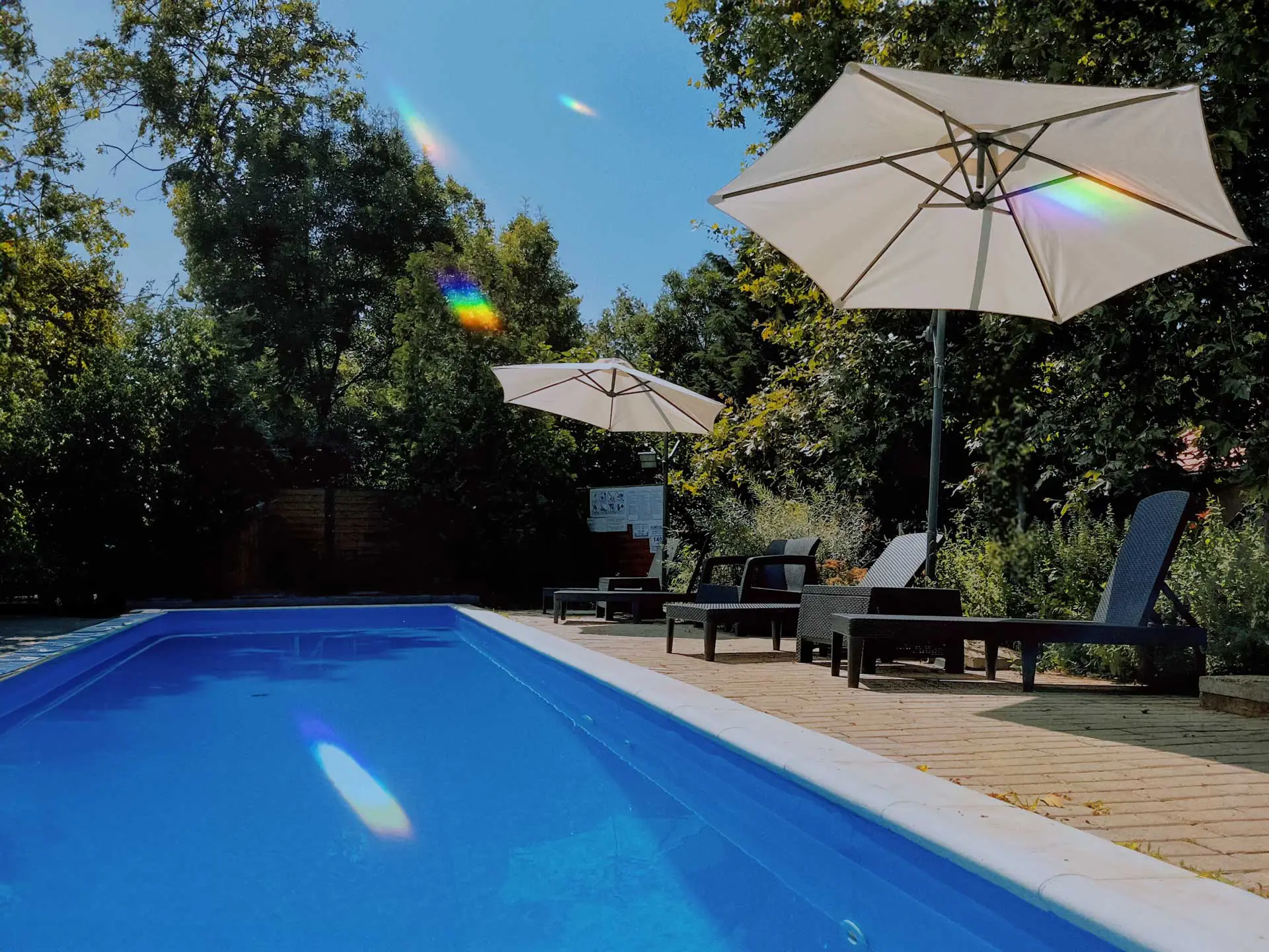 Napernyők és napágyak a Platán Garden & Rooms medencéje mellett